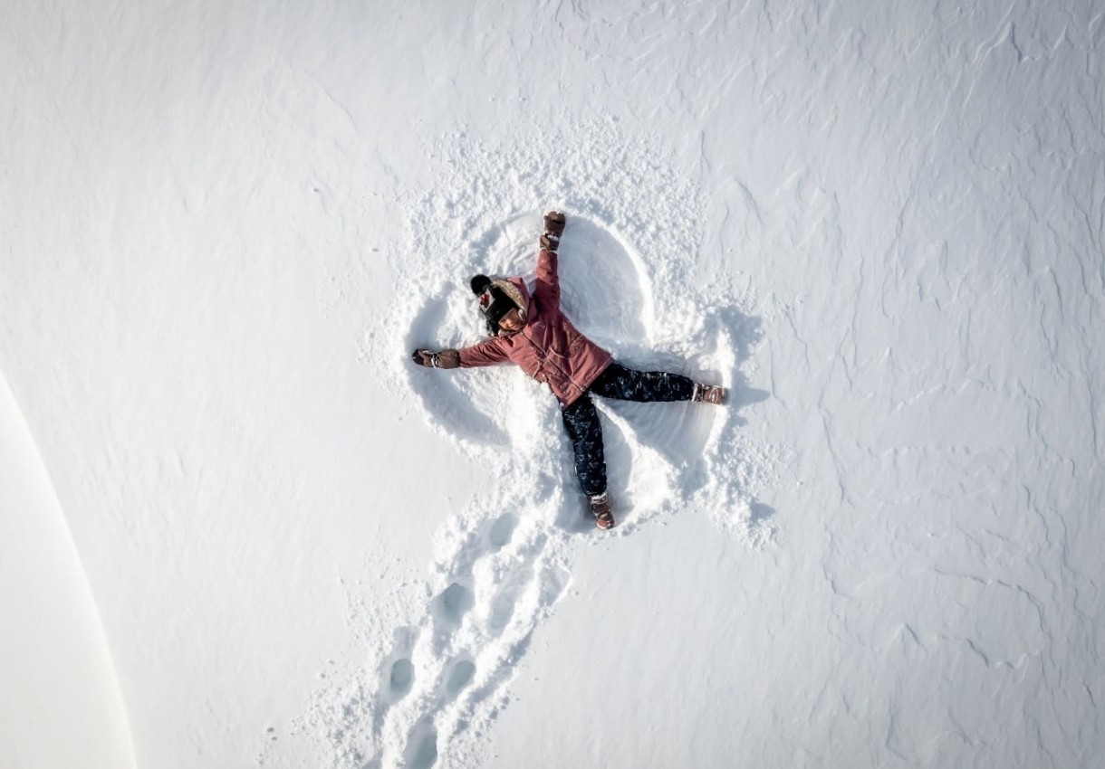 Kind liegt im frischen Schnee und macht einen Schneeengel © TVB Großarltal/Gipfelfieber