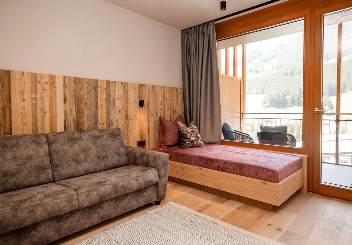 Modernes Wohngefühl mit Naturblick – stilvolle Suite mit Fensterfront im Hotel Dorfer